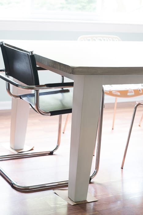 picture of black cantilever and white plastic chair at the table to show height