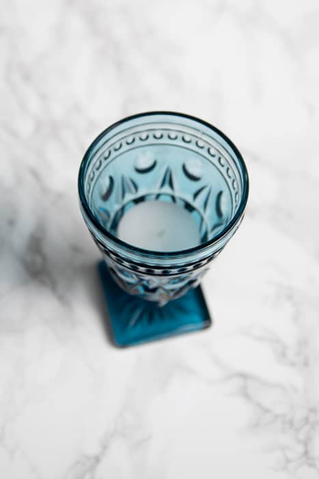 picture showing small blue pressed glass goblet containing a tea light