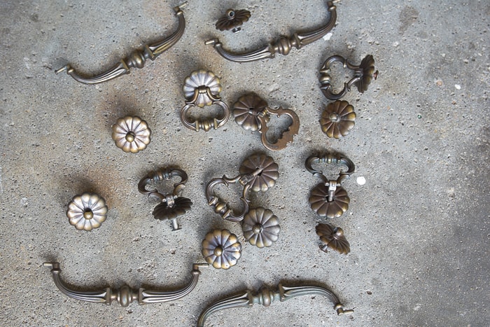 picture of tarnished brass handles and knobs on concrete