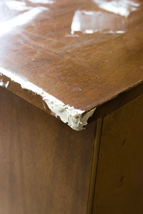 Picture of damaged corner of wood dresser with wood filler