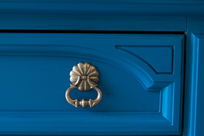 picture of section of drawer painted teal and gold hardware