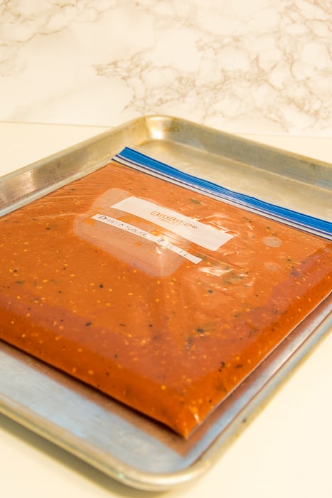 Picture of tomato sauce in freezer bag on cookie sheet