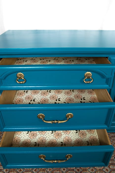 picture of three open dresser drawers showing bush pink and gold floral paper lining