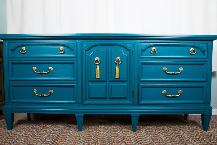 picture of teal dresser with gold hardware and tassels