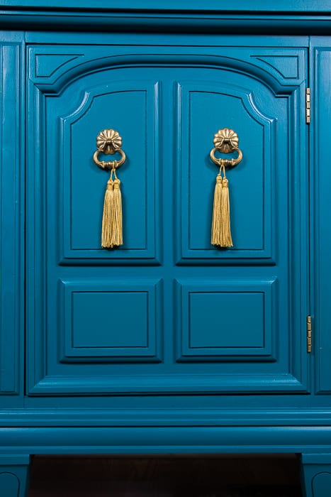 picture of teal dresser door with gold hardware and gold tassels