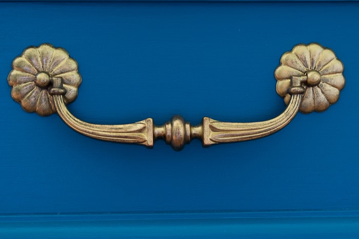 picture of restored brass hardware on teal dresser front