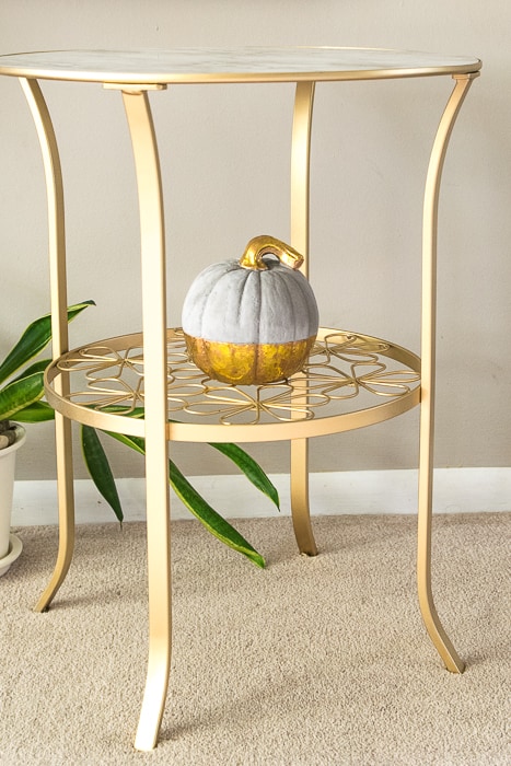 picture of finished gold painted table from side with small concrete and gold pumpkin