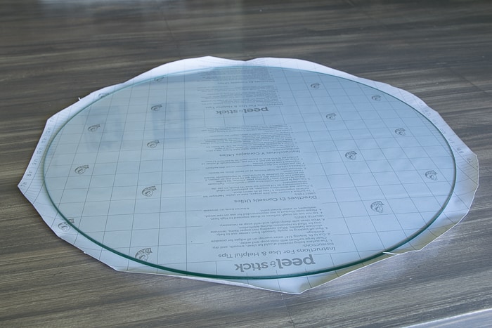 picture showing round glass top with shelf paper cut to size with 1 inch overhang