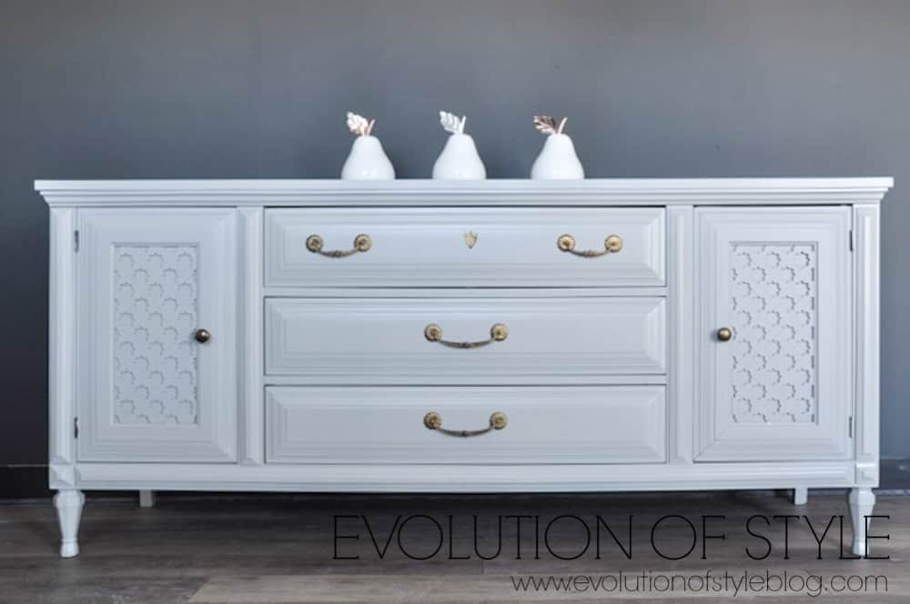 picture showing light gray dresser with three white ceramic pear sculptures 