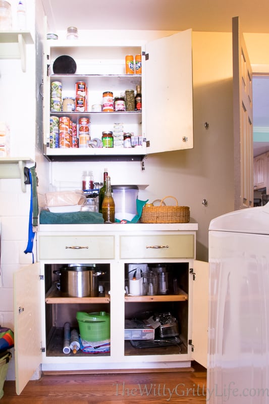 Cabinets in laundry room with doors open before makeover