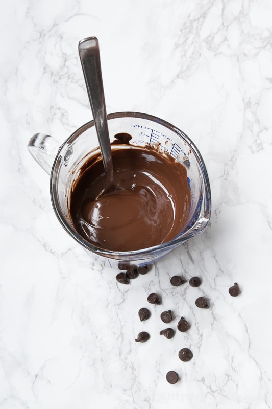 chocolate glaze in a measuring cup and chocolate chips