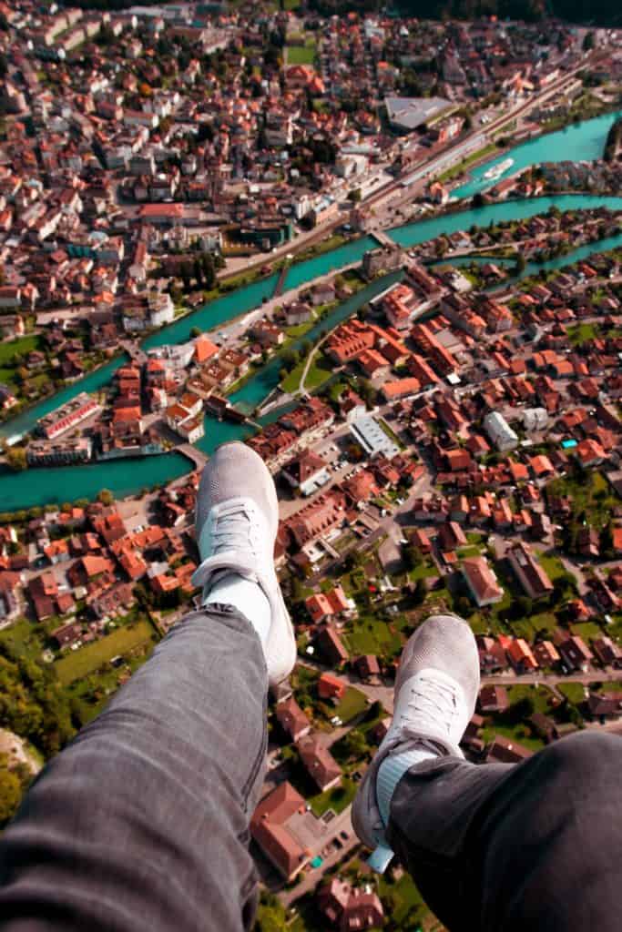 feet dangling high over houses