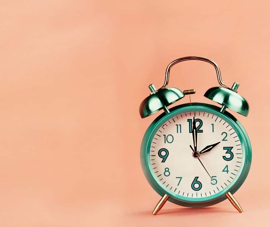 shiny clock in front of pink background