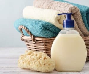 make liquid soap, soap dispenser, basket of towels and sponge