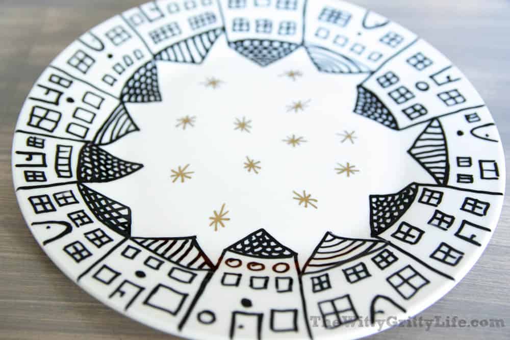 white plate with black houses around the rim and gold stars in the center