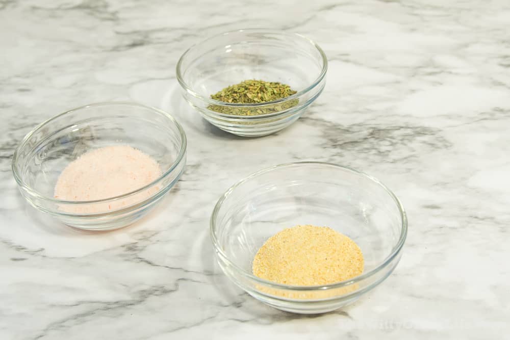 small bowls with garlic powder, himalayan salt and Italian herbs, the basic ingredients of pizza sauce