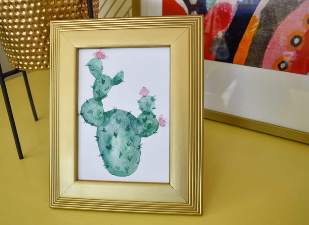 image showing watercolor print of a cactus in a gold frame