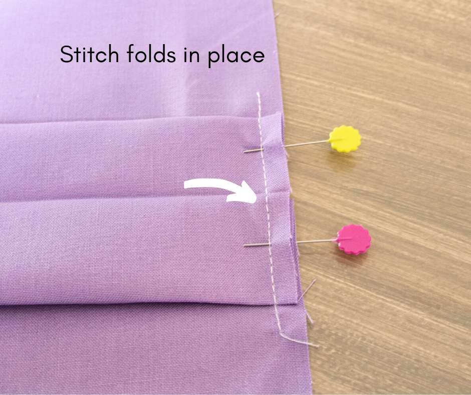 image showing centerfold stitched with 2 pins still in place and arrow pointing toward stitch line