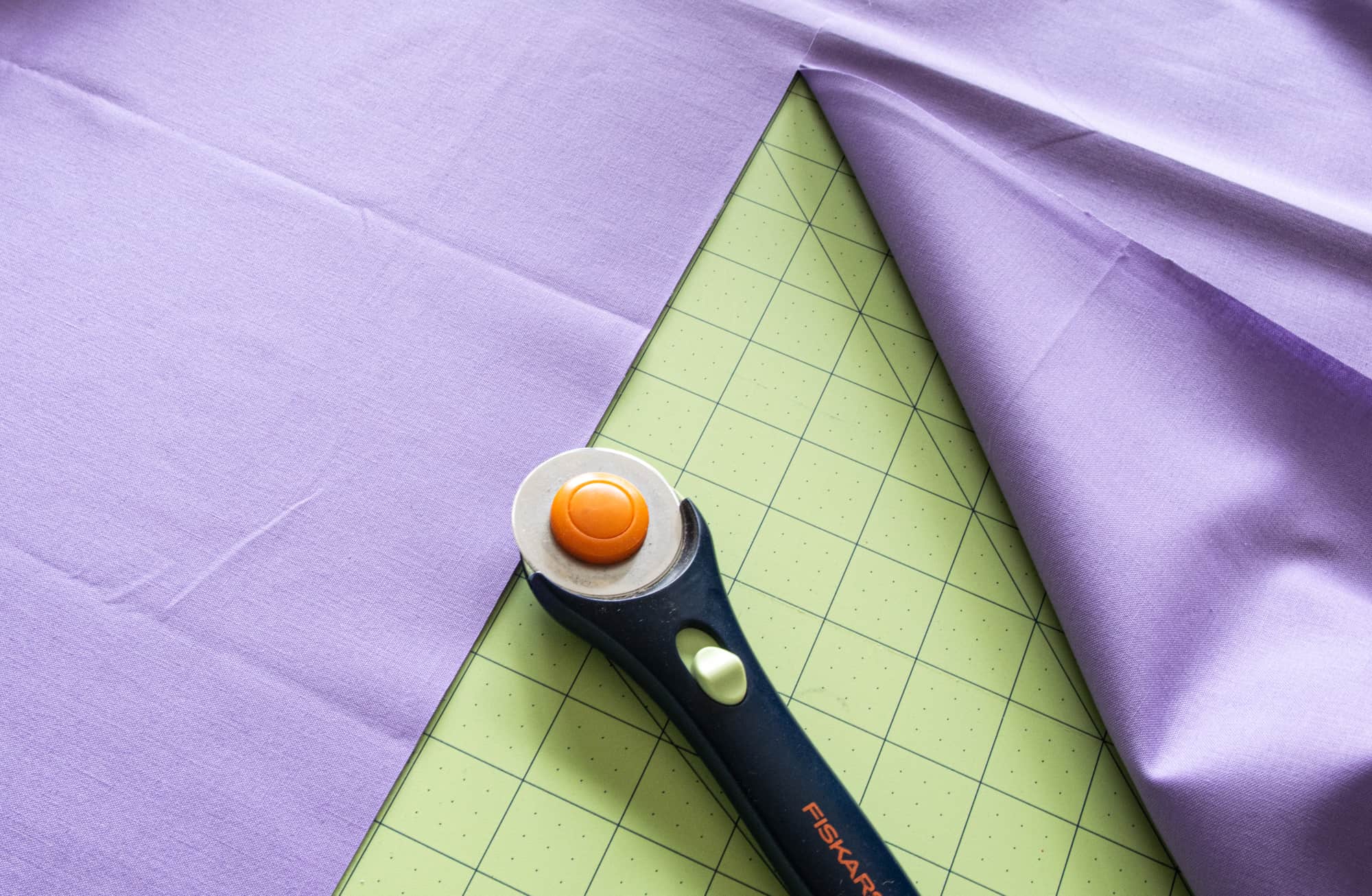 image showing fabric on cutting mat and rotary cutter for cutting fabric for washable face masks