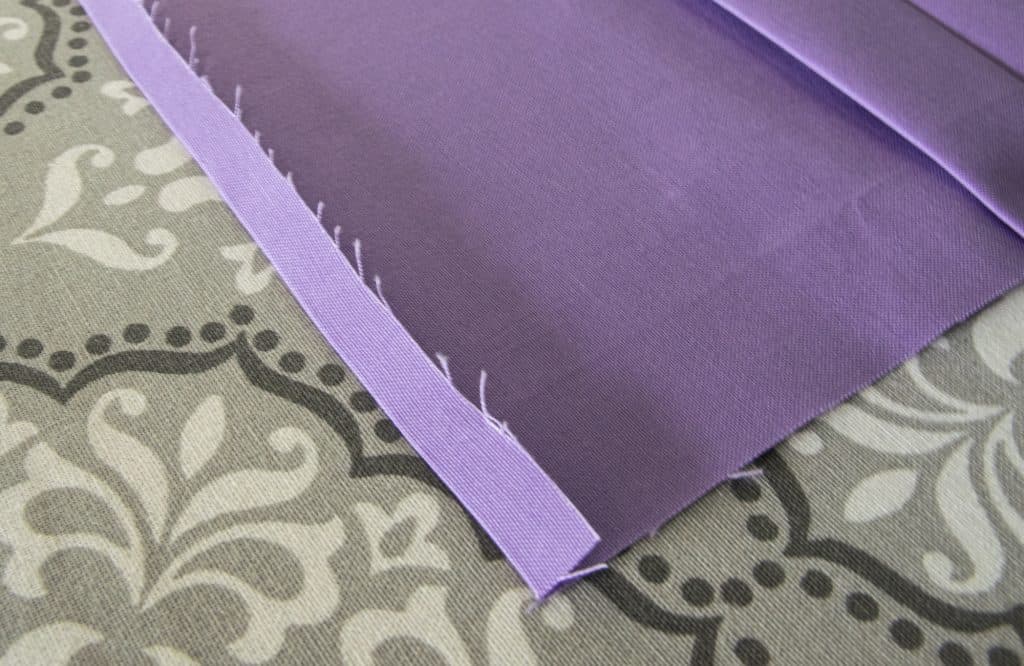 image showing seam rolled up and pressed on one end of fabric for  washable face mask